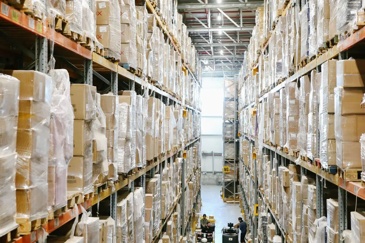 Warehouse aisle with cardboard boxes arranged on tall storage shelves